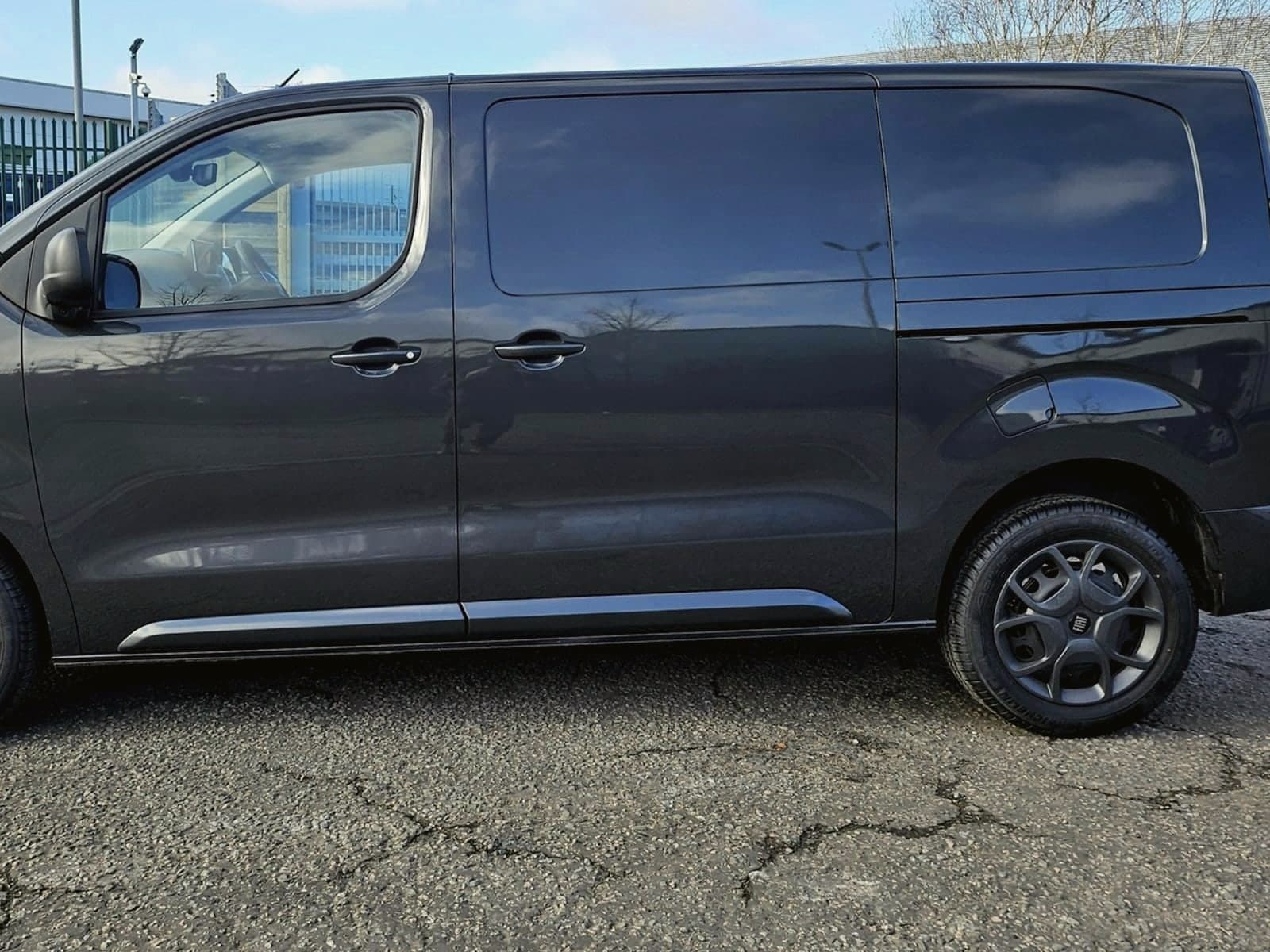 Clean dark commercial van parked in a service yard