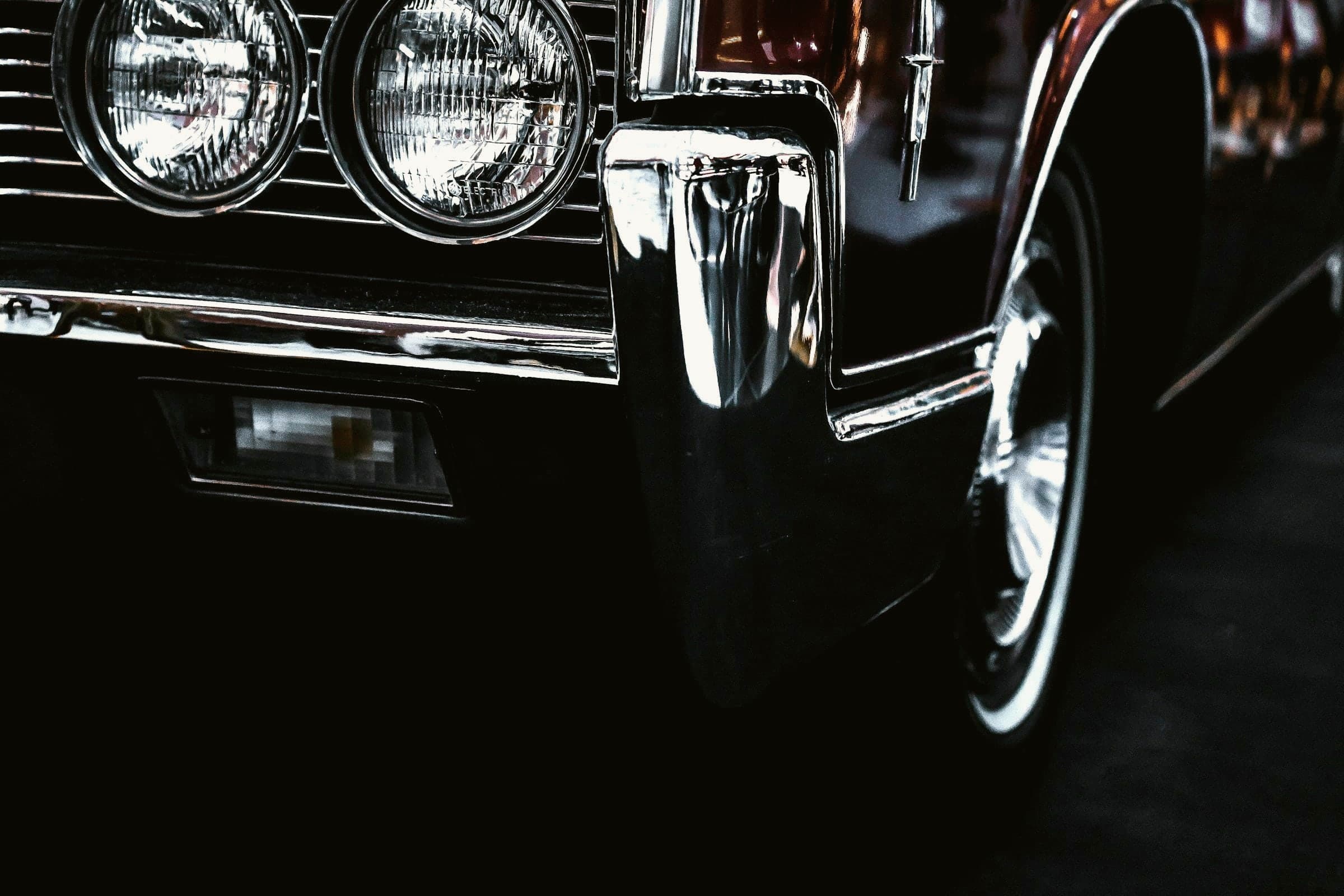 Freshly detailed dark car with light reflecting along the wet paint