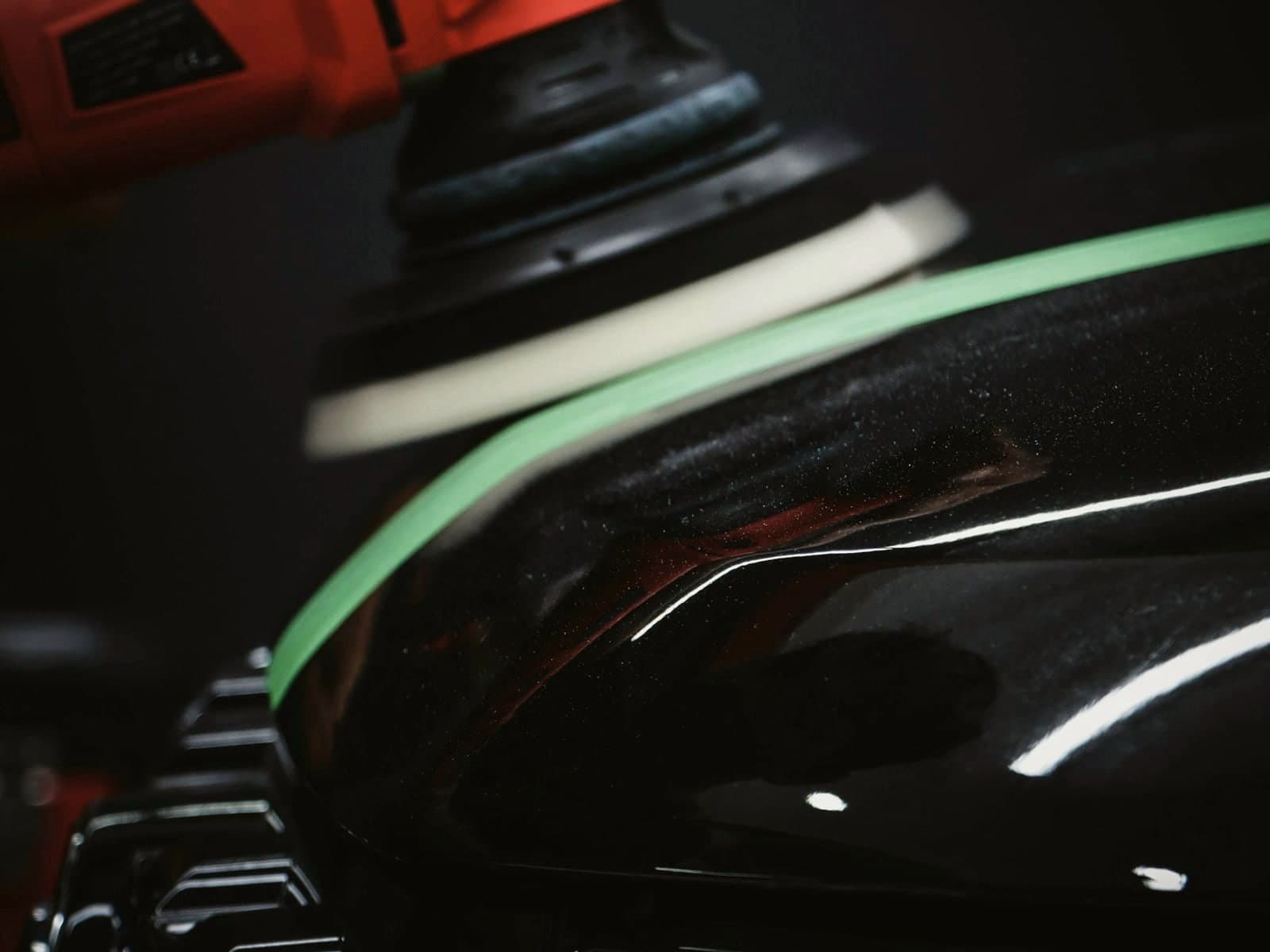 Machine polisher working across a painted car panel